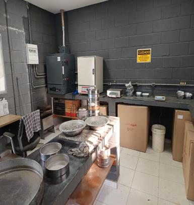Laboratório de ensaios de asfalto montado na unidade, com bancadas, peneiras, estufas e equipamentos